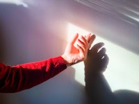 the shadow of a person's hand on a white wall